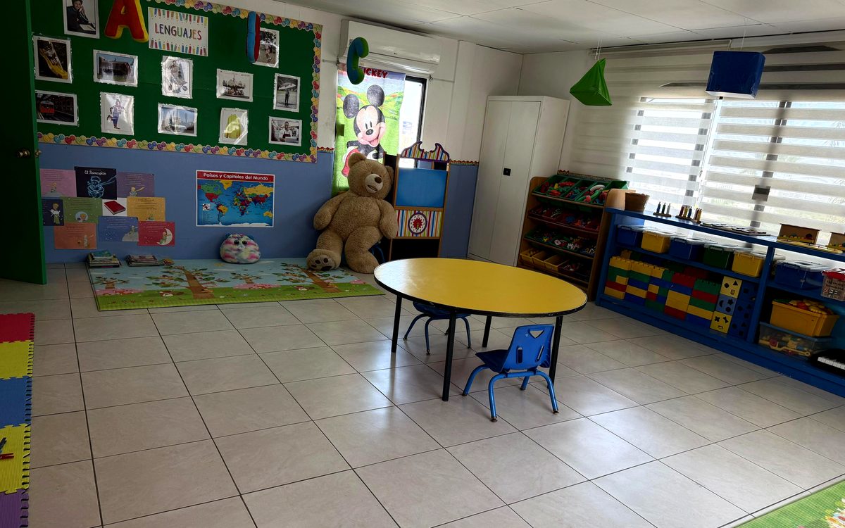 Rincón de lectura del salón de Kínder Lety con libros, tapetes y aire acondicionado